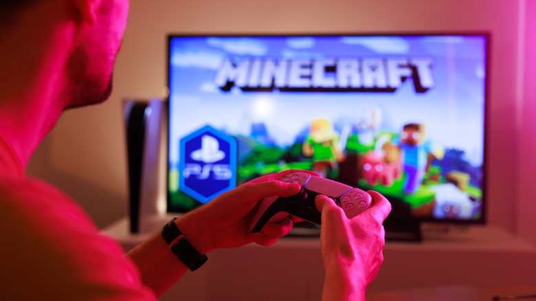 Человек, играющий в Minecraft на телевидении с контроллером