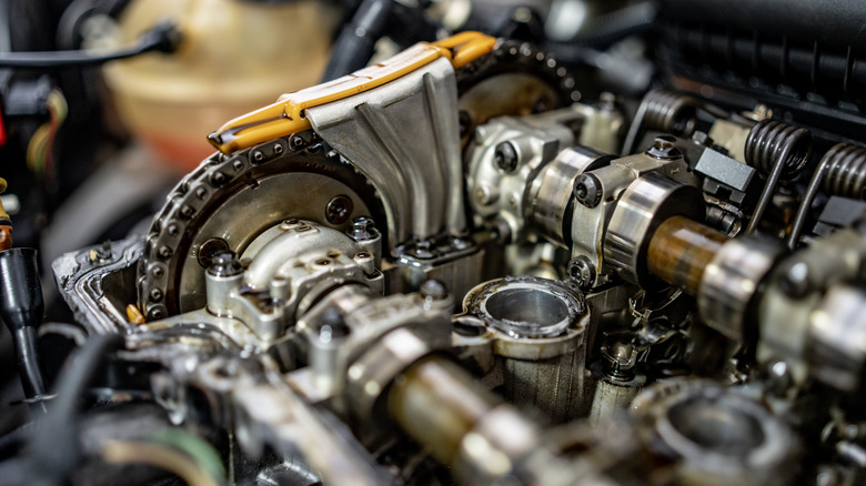 Подробный вид распределительного вала и снятых снятых компонентов автомобильного двигателя с клапаном и крышкой ГРМ