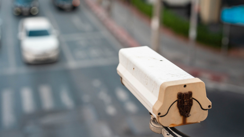 Автоматическая камера считывателя номерного знака сзади с видом на оживленный перекресток.