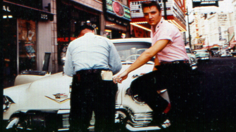 Элвис Пресли, опирающийся на Cadillac