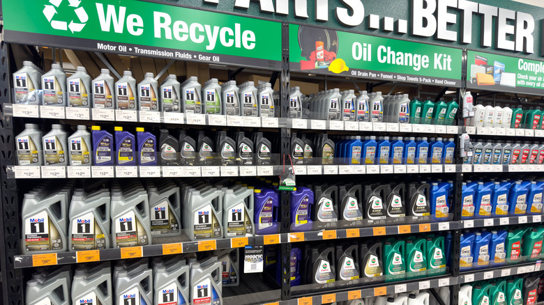 Стойка моторного масла в магазине со знаком, в котором говорится 