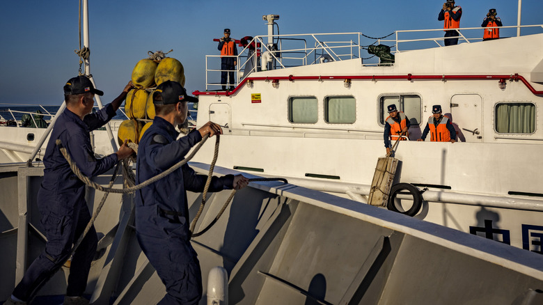 Филиппинский персонал береговой охраны BRP Sindangan и китайской береговой охраны развертывает крылья, когда они готовится к столкновению