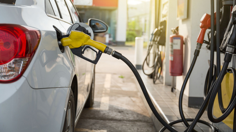 Белый Chevrolet Cruze заправляется на заправке