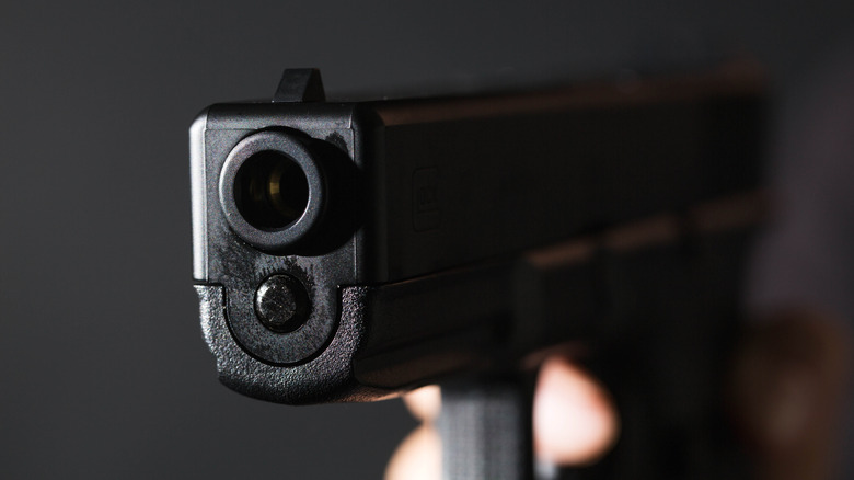 Крупным планом ствола для пистолета на темном фоне