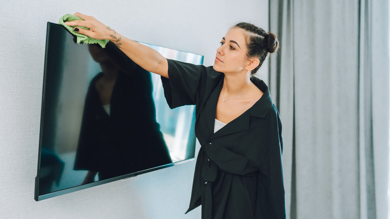 Женщина, высыпающая вершину телевизора