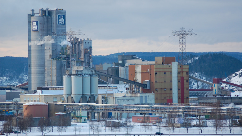 Хакер сидит в темной комнате, используя несколько экранов для взлома компьютеров.