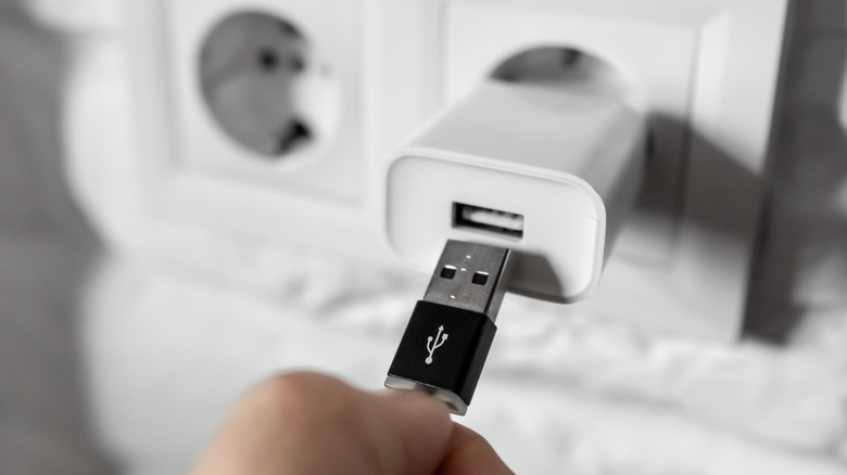 человек подключает кабель к кирпичу зарядки