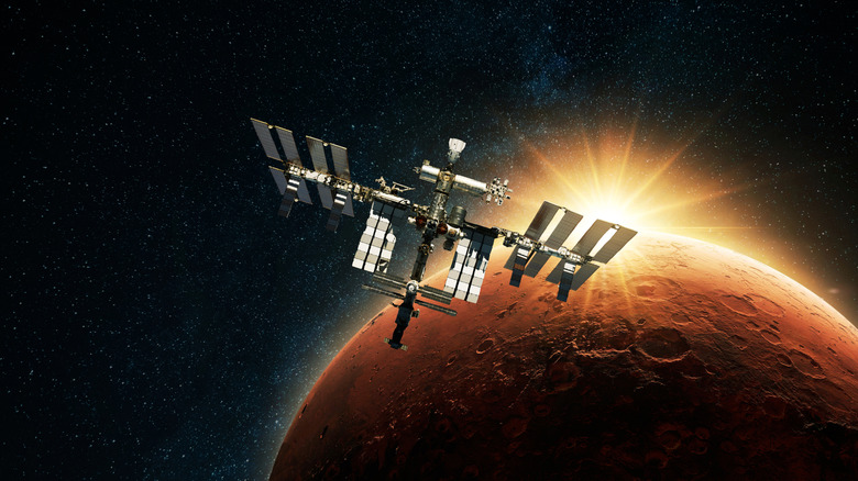 Космическая станция, плавающая на орбите Марса, за которой светит солнце.