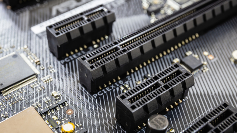 Крупный план четырех рядов слотов или линий PCIe на материнской плате.