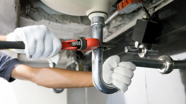 Сантехник чинит раковину