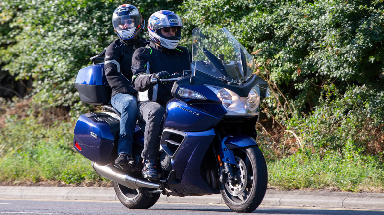 Байкер и пассажир едут на Triumph Trophy 1200 SE в солнечный день.