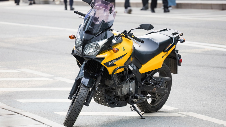 Черно-желтый Suzuki V-Strom 650, припаркованный на городской улице.