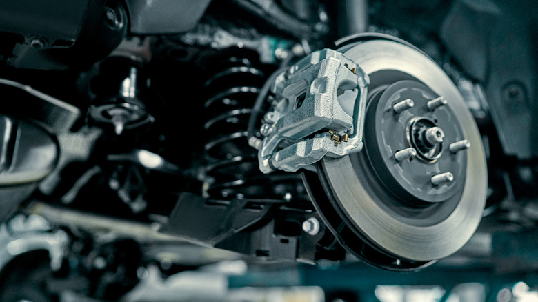 Задний тормозной диск меньшего размера с серебряным суппортом.