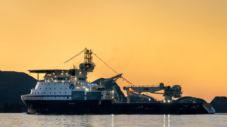 Остров Победы плывет недалеко от берега на закате.