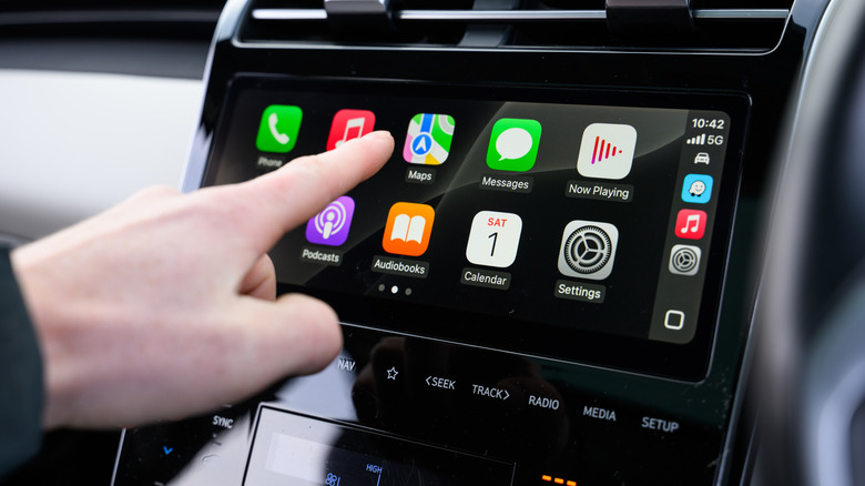 Рука, управляющая Apple CarPlay в автомобиле