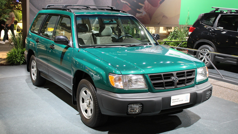 Зеленый Subaru Forester 1999 года выпуска, припаркованный на автосалоне, вид спереди на 3/4.