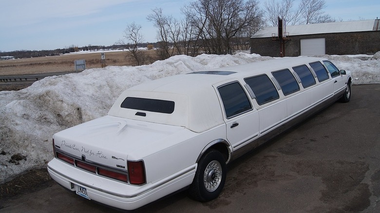 Лимузин Lincoln Town Car 1997 года выпуска припаркован возле снежных заносов.