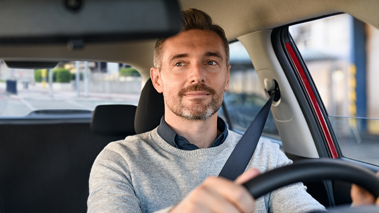 Водитель смотрит в зеркало заднего вида