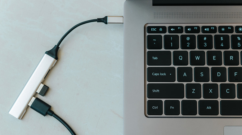 Вид сверху на открытый Chromebook с подключенным USB-концентратором.