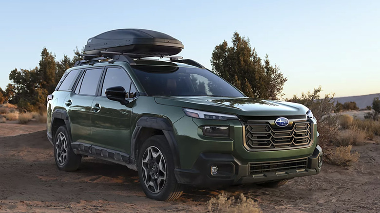 Вид спереди справа на зеленую субару, припаркованную в пустыне