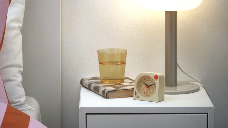 Будильник Tjinga стоит на прикроватной тумбочке