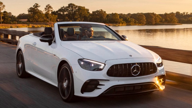 Белый кабриолет Mercedes едет по озеру