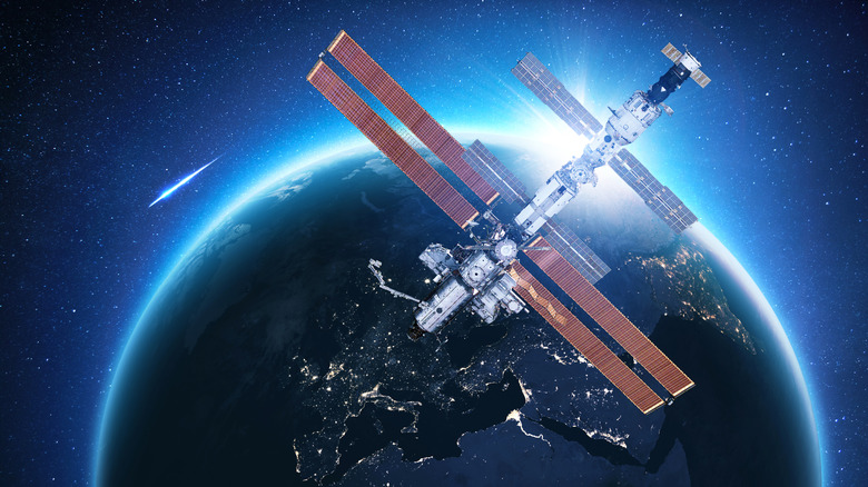 Международная космическая станция над Европой на фоне падающей звезды.