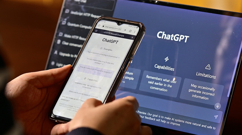 Руки держат смартфон, на котором отображается ChatGPT, и ноутбук, на заднем плане также отображается ChatGPT.