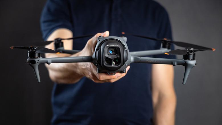 Человек, держащий дрон DJI.