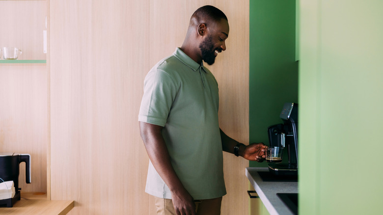 Человек пользуется кофемашиной.