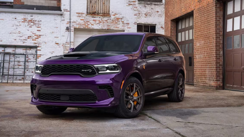 Фиолетовый Dodge Durango припаркован возле кирпичных зданий