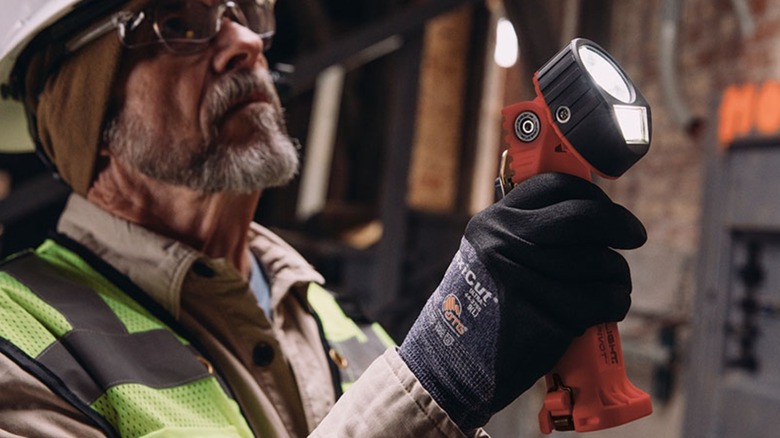 Человек, использующий фонарик Streamlight