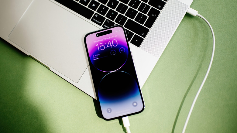 iPhone 15 Pro, подключенный к MacBook Pro с помощью кабеля USB-C.