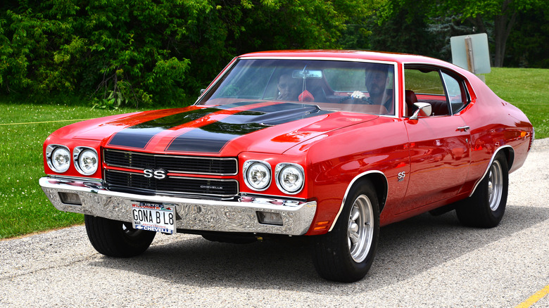 Красный Chevrolet Chevelle SS 454 1970 года выпуска за рулем