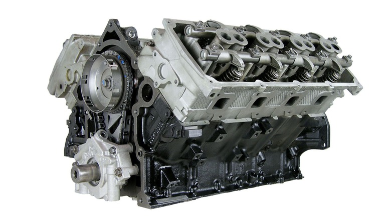 Двигатель ATK HP103 в ящике на белом фоне, вид спереди слева