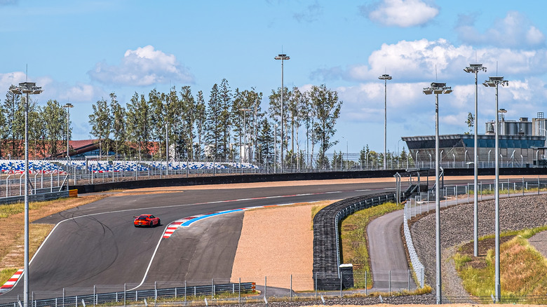 Одинокая красная гоночная машина на углу трассы Игора Драйв.