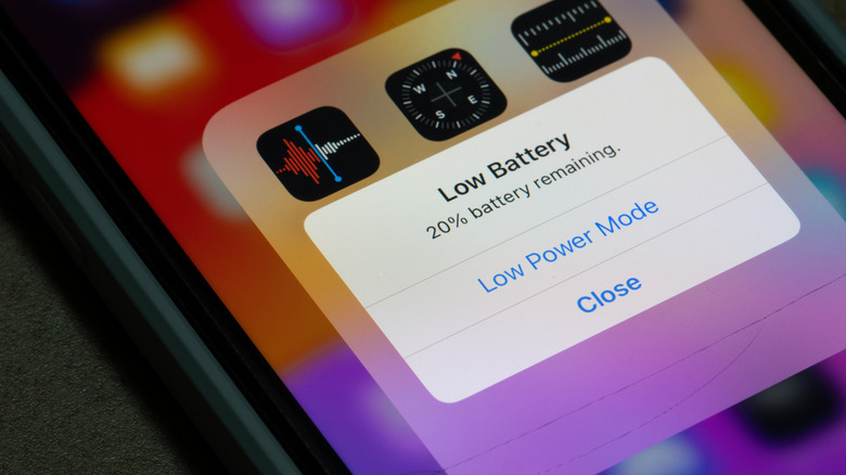 Экран iPhone со всплывающим сообщением о низком заряде батареи