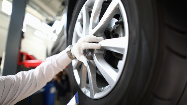 Автопрофессионал осматривает колесо автомобиля