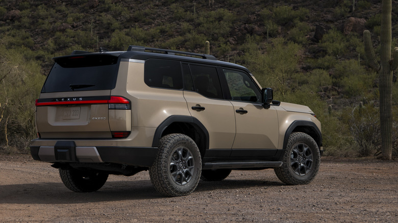 Бронзовый Lexus GX 2026 года, припаркованный в пустыне, вид сзади в три четверти