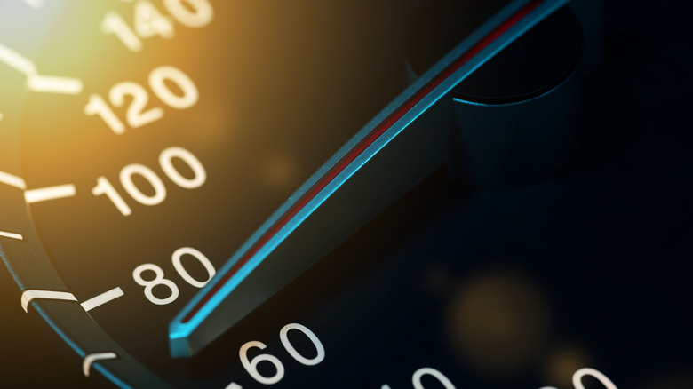 Крупный план аналогового спидометра со стрелкой от 60 до 80 км/ч.