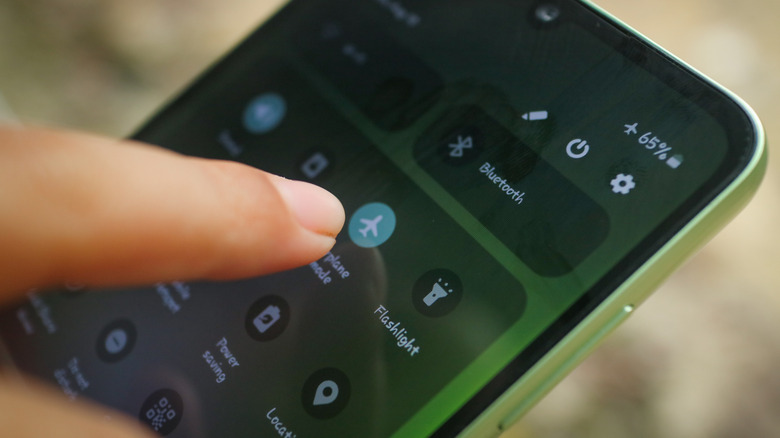 Человек, активирующий режим полета на смартфоне Android