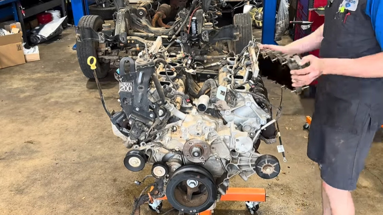 Механик снимает клапанную крышку с Ford Godzilla V8