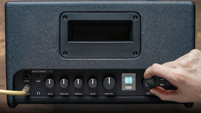 Рука возится с горшками на усилителе.