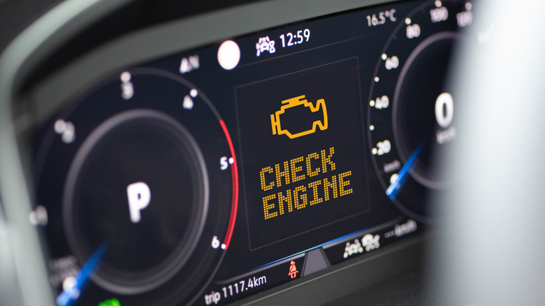 Крупный план приборной панели автомобиля с большим желтым уведомлением Check Engine.
