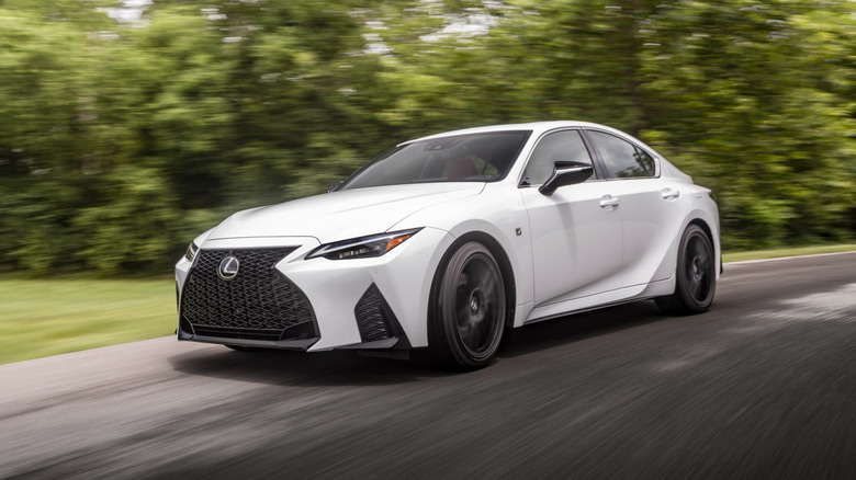 Вид сбоку белого Lexus IS 2025 года за рулем.