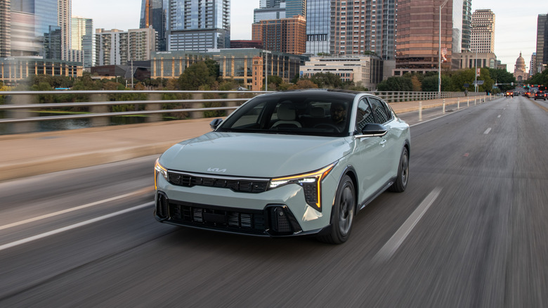 Вид спереди Kia K4 2025 года за рулем.