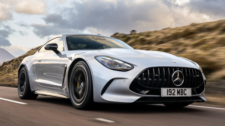 Вид спереди 3/4 на Mercedes-AMG GT 63 Coupe на дороге на фоне гор