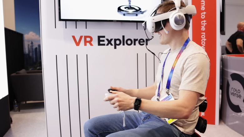 Мужчина сидит на кресле Roto VR Explorer и играет в VR-игру.