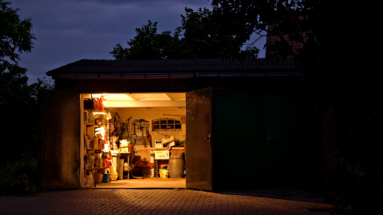 Открытые ворота гаража, свет включен.