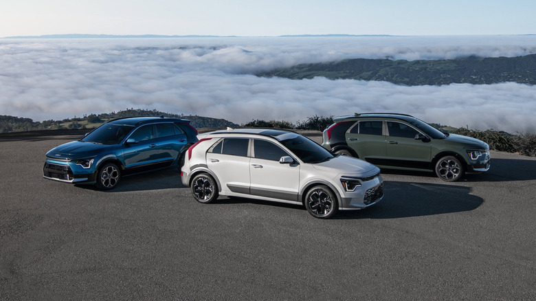 Модельный ряд Kia Niro на вершине холма с облаками внизу
